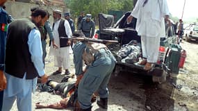 La police afghane déplaçant les victimes de l'attentat suicide à à Pul-e-Khumri lundi.