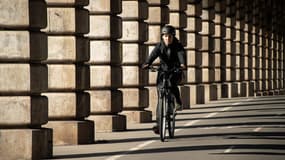 Une cycliste sous le pont de Bercy, à Paris