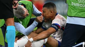 Kylian Mbappé en train de se faire soigner le nez lors de France-Autriche