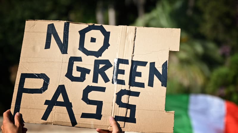 Un membre du groupe "No Vax" brandit une pancarte lors d'une manifestation contre l'introduction d'un "green pass" obligatoire dans le but de limiter la propagation du Covid-19, sur la Piazza del Popolo, dans le centre de Rome, le 7 août 2021.
