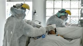 Deux infirmiers s'affairent autour d'un malade atteint du Covid-19 - Image d'illustration 