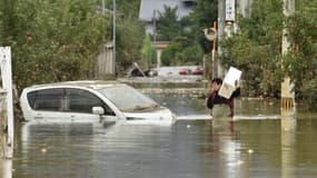 Un homme dans une rue inondée de Nagano, au Japon, le 14 octobre 2019