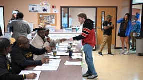 Les agents électoraux aident les gens à s'inscrire pour voter dans un bureau de vote à Milwaukee, le 5 novembre 2024.