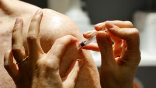 Un pharmacien vaccine un patient contre la grippe à Paris le 13 octobre 2020