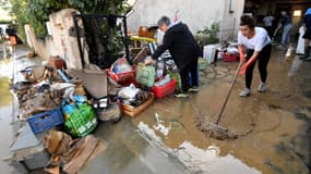 Des habitants de Villeneuve-les-Béziers, dans l'Hérault, nettoient leur maison après les violentes intempéries qui ont touché le département, le 24 octobre 2019