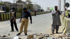 Les officiers de sécurité pakistanais inspectent les lieux du drame où 13 personnes ont été blessées. 