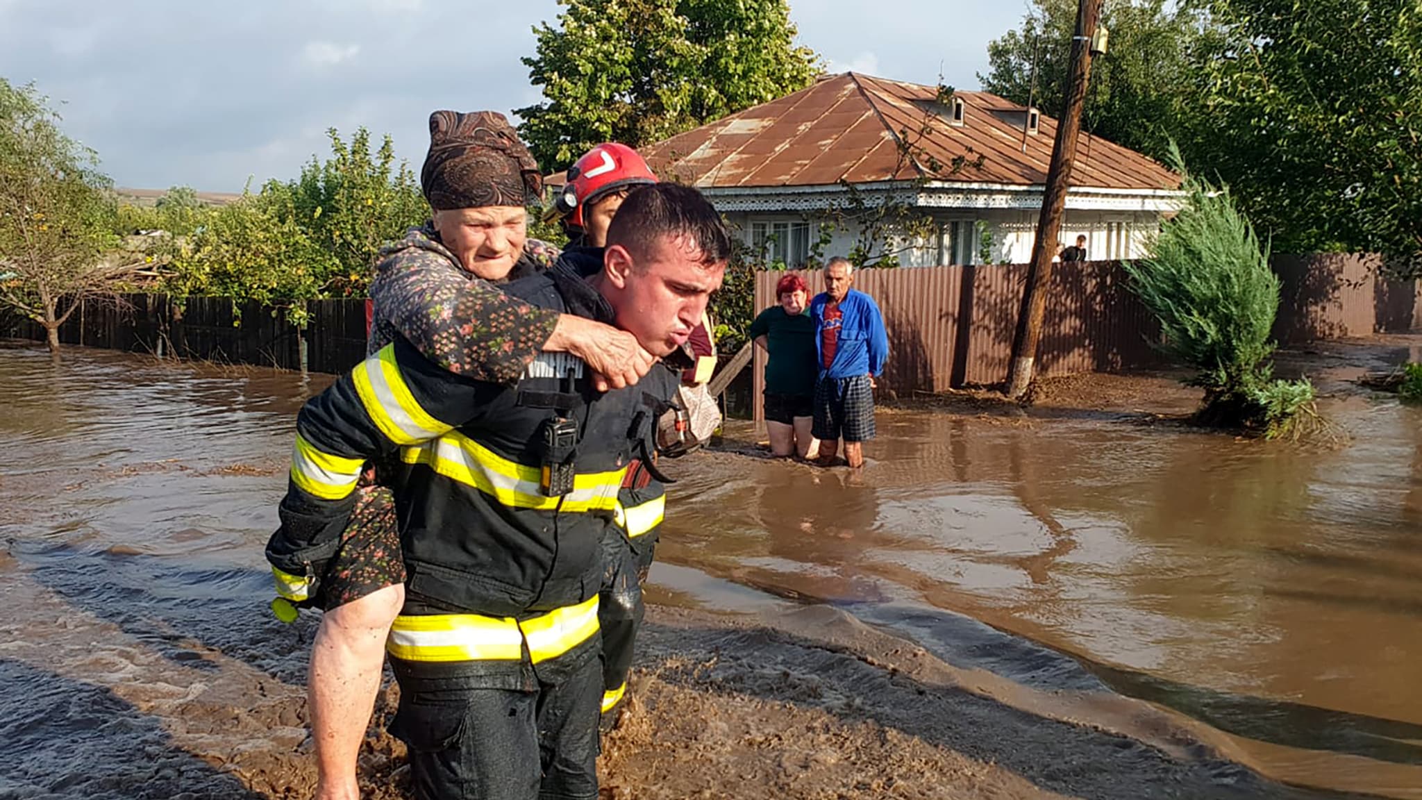 Cette photo prise le 14 septembre 2024 montre un secouriste transportant une femme âgée dans les inondations à Pechea, dans le comté de Galati, en Roumanie.