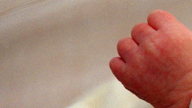 Un nouveau-né, Tom, ferme son poing dans son berceau durant son sommeil, le 5 juin 2001 au service maternité de l'hôpital franco-britannique de Levallois-Perret.