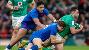 Matthieu Jalibert plaque Hugo Keenan devant Yoram Moefana lors d'Irlande-France (32-19, VI Nations), le 11 février 2023
