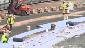 La pose de la nouvelle piste d'athlétisme au Stade de France