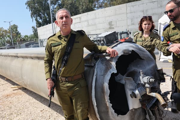 Le porte-parole militaire israélien, le contre-amiral Daniel Hagari pose, le 16 avril 2024, à côté d'un missile balistique iranien tombé en Israël le week-end dernier.