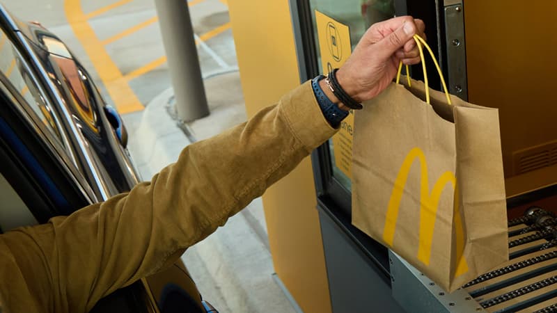 Un client recevant sa commande depuis un McDonald's quasiment automatisé.