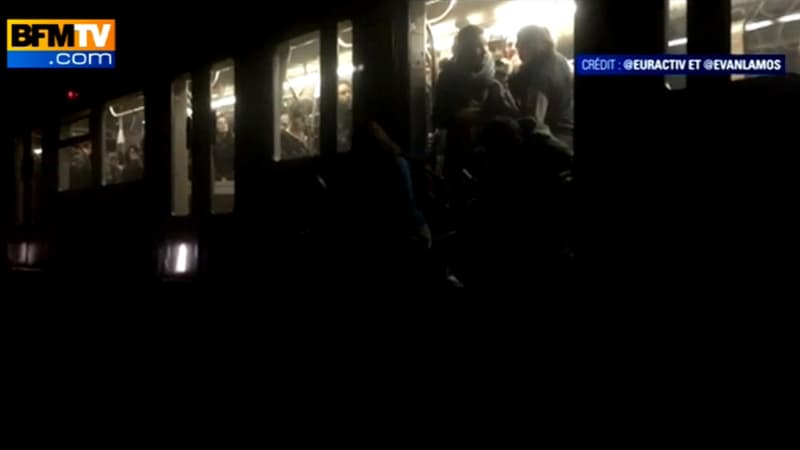 Les passagers bloqués dans le métro tentent d'évacuer une rame plongée dans l'obscurité, mardi.