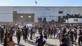 Des Palestiniens déplacés transportent des sacs d'aide alimentaire après avoir pris d'assaut un entrepôt du Programme alimentaire mondial à Deir el-Balah, dans le centre de la bande de Gaza, le 28 mai 2025.