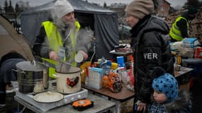Des bénévoles offrent des boissons chaudes et de la nourriture aux réfugiés ukrainiens au poste frontière de  Medyka, dans l'est de la Pologne, le 9 mars 2022