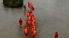 Des secouristes dans une rue inondée de Zhengzhou (Chine), le 23 juillet 2021.