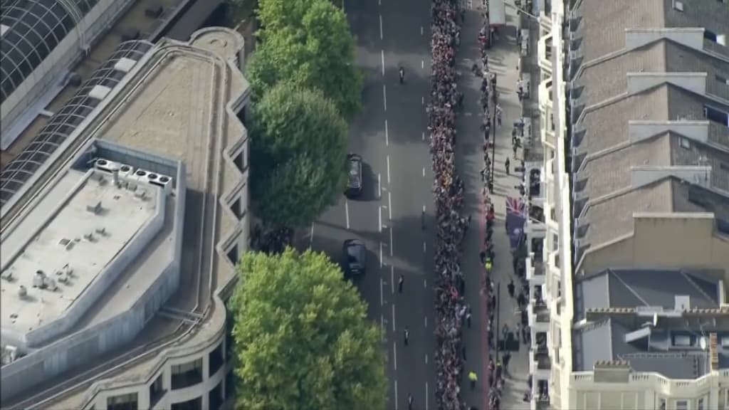 Une foule de personnes attend le cortège de la reine. Une foule de personnes attend le cortège de la reine.