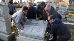 Des membres de la communauté juives de Philadelphie remettent d'aplomb une pierre tombale vandalisée, le 26 février.