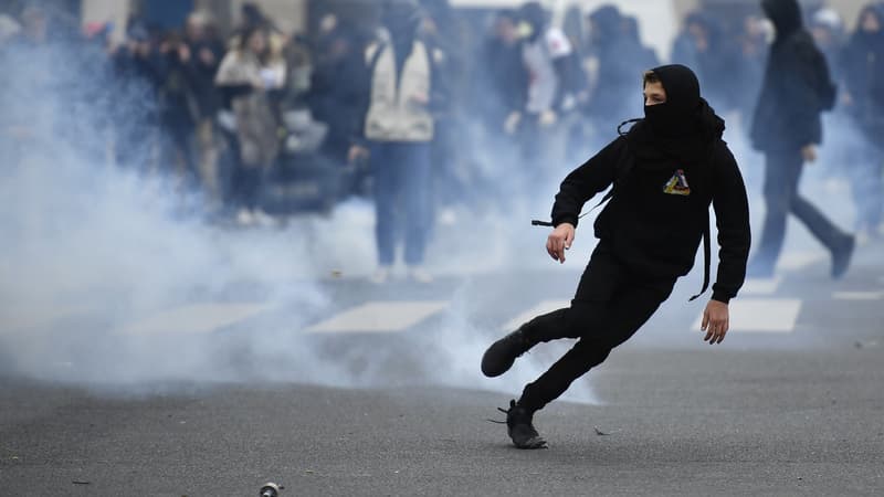 Un jeune homme s'éloigne d'un nuage de gaz lacrymogène tiré par la police lors de manifestations contre les violences policières, près du lycée Voltaire le 23 février 2017 à Paris.