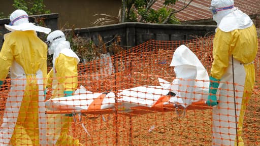 Le personnel de Médecins sans Frontières portent le corps d'une personne tuée par la fièvre hémorragique, en Guinée, le 1er avril 2014.