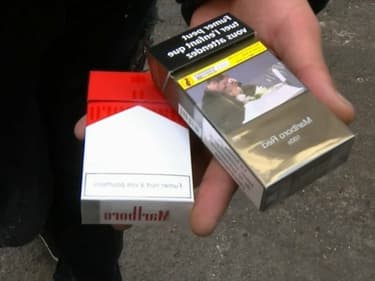 Un trafiquant de cigarettes de contrebande exhibe deux paquets