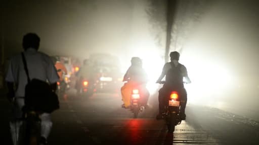 Des usagers roulent en scooters lors d'une tempête à Allahabad, en Uttar Pradeshn dans le nord de l'Inde, le 13 mai 2018