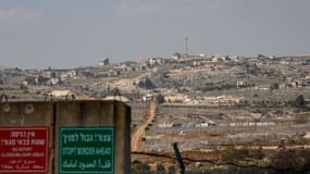 Un panneau militaire israélien se trouve à la frontière israélo-libanaise, avec en toile de fond le village libanais de Blida, le 17 février 2025