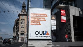Une photo prise à Lausanne le 18 juin 2023 montre une affiche électorale sur laquelle on peut lire "Investir dans notre avenir, Oui à la loi sur le climat le 18 juin".