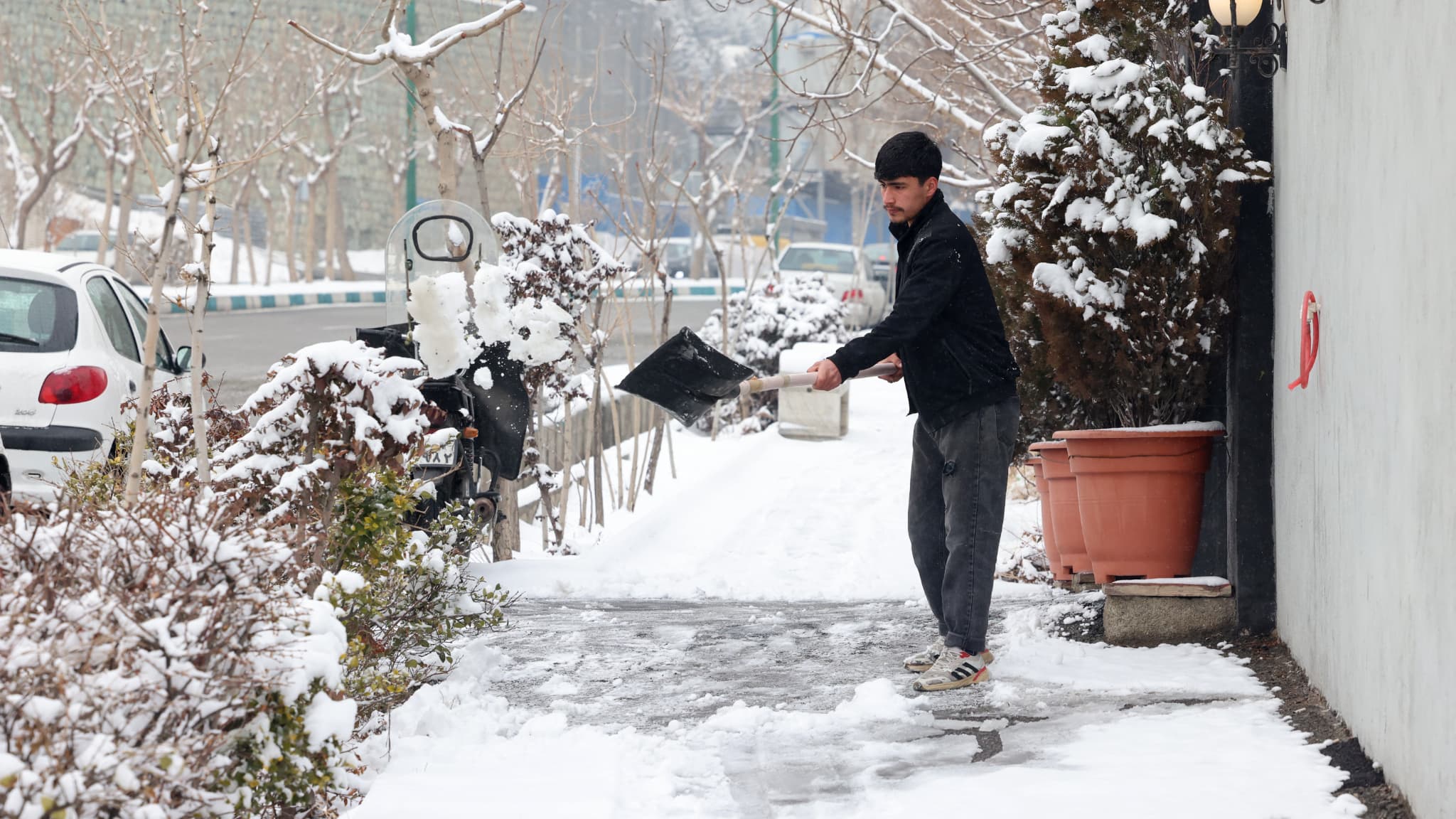 Un homme déneige un trottoir à Téhéran, le 9 février 2025.