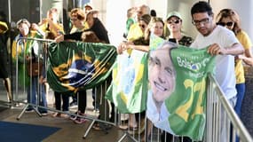 Des partisans de l'ancien président brésilien Jair Bolsonaro attendent son arrivée au siège du Parti libéral à Brasilia, le 30 mars 2023.