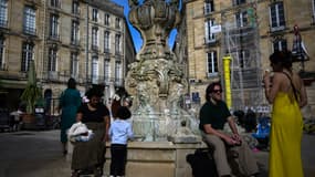 Une femme mange une glace près d'une fontaine à Bordeaux, dans le sud-ouest de la France, le 5 avril 2024. Des températures élevées pour début avril se font sentir dans le sud-ouest, en particulier à Bordeaux, où les habitants profitent des températures douces du centre-ville parcs et au bord de la Garonne.