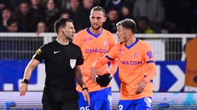 L'arbitre Jérémy Stinat en train de discuter avec le Marseillais Quentin Merlin lors du match Auxerre-OM, le 22 février 2025