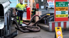 Un camion-citerne Total réapprovisionne en carburant une station-service. 