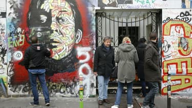 Des personnes se rendent en 2016 devant l'entrée du 5 bis rue Verneuil à Paris, maison de Serge Gainsbourg, lors du 25e anniversaire de sa mort