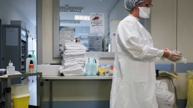 Une interne enfile des gants de protection dans le service de médecine interne de l'hôpital Emile Muller de Mulhouse, le 16 février 2021