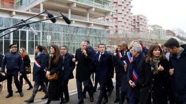 Le président Emmanuel Macron (c) visite le village olympique, le 29 février 2024 à Saint-Denis, au nord de Paris