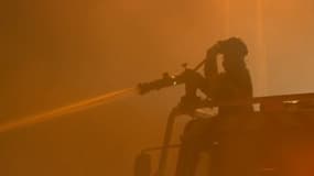 Des sapeurs-pompiers font face aux flammes aux alentours de Saumos, en Gironde, dans la nuit du 12 au 13 septembre 2022