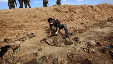 Un homme inspecte un charnier découvert par des forces kurdes en Irak et contenant des restes de membres de la communauté yézidie massacrés par Daesh, en février 2015