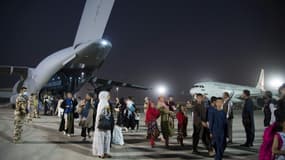 Photo fournie par l'Etat-major français des Armées le 26 août 2021, d'Afghans évacués de l'aéroport de Kaboul débarquant d'un avion militaire français à la base aérienne d'Al Dhafra, près d'Abou Dabi