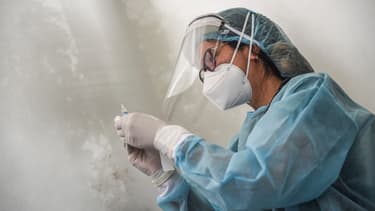 Médecin chinoise munie d'une dose de vaccin.