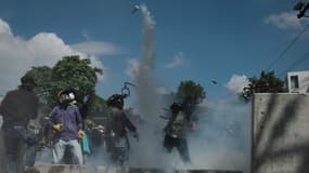 Les manifestants anti-gouvernement renvoient du gaz lacrymogène aux forces de l'ordre à Bangkok en Thaïlande le 1er décembre 2013.