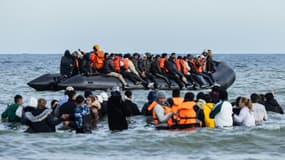 Des migrants montent à bord d'un bateau de passeurs pour tenter de traverser la Manche, au large de la plage de Gravelines, dans le nord de la France, le 26 mars 2025