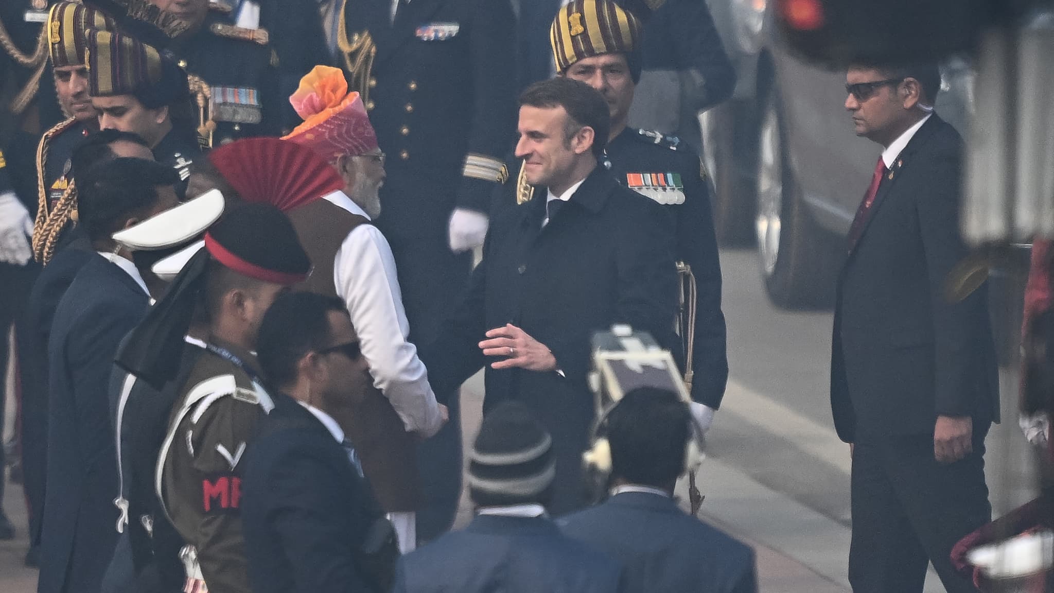 Le Premier ministre indien Narendra Modi (C,G) salue le président français Emmanuel Macron (C,D), à son arrivée pour assister au défilé du 75e jour de la République indienne à New Delhi, le 26 janvier 2024. 