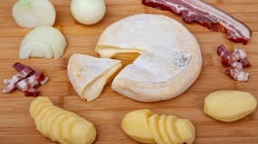 Un reblochon avec les ingrédients pour une tartiflette.