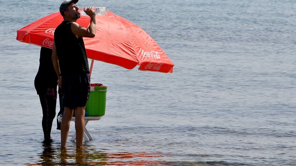 Un Tunisien s'hydrate sur une plage de Tunis, le 24 juillet 2023 Un Tunisien s'hydrate sur une plage de Tunis, le 24 juillet 2023