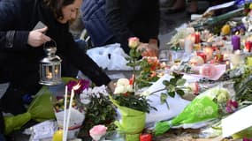 Une femme dépose une bougie en mémoire des victimes des attentats du 13 novembre, à Paris.
