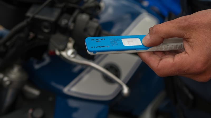 Un gendarme montre un test salivaire positif au THC.