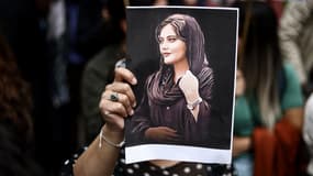 Un manifestant tient un portrait de Mahsa Amini lors d'une manifestation en sa faveur devant l'ambassade d'Iran à Bruxelles le 23 septembre 2022.