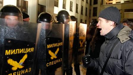 Face-à-face entre un manifestant et des policiers anti-émeutes lors d'un rassemblement d'opposants, dimanche à Minsk. Au moins quatre des neuf candidats qui étaient en lice face au chef de l'Etat sortant Alexandre Loukachenko à la présidentielle de dimanc