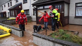 Des secouristes évacuent une famille coincée dans une rue inondée à Brechin, au nord-est de l'Écosse, le 20 octobre 2023, alors que la tempête Babet s'abat sur le pays.
